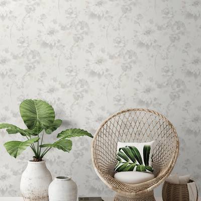 Boho Interior Setting mit Rattansessel und grüner Pflanze vor floraler Mustertapete von heineking24